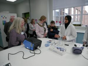 A student demonstrate DNA profiling techniques to Alison Webster, Chief Executive of Thames Valley Berkshire LEP, The Mayor of Reading, Councillor Rachel Eden and her son.