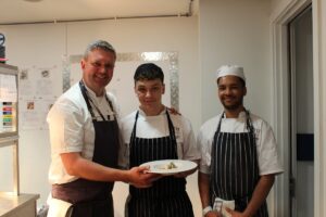 Adam Johnson, Operations Director for Raymond Blanc Consultancy, with students Gracjan and Keanu. 