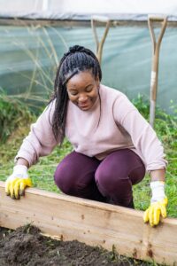 A volunteer from Virgin Media and O2 plants a raised bed in the gardening area at Reading College