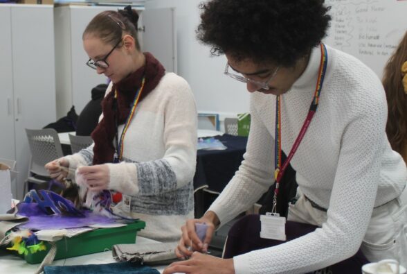 Leo and a member of staff making bags