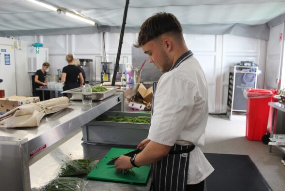 Frankie Ryan-Swift, a Professional Culinary Arts Level 1 student at Reading College preparing green beans while on work experience at Royal Ascot