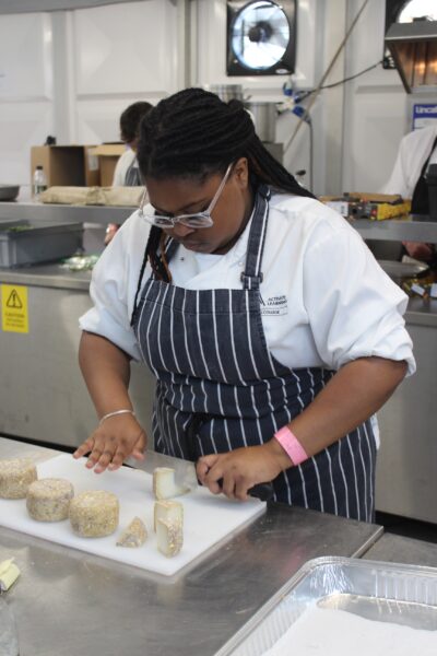 Jacalyn Richardson, a Professional Culinary Arts Level 2 student at Reading College cutting some cheese at Royal Ascot