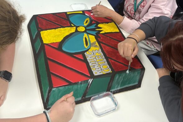 Picture of the Christmas present-themed wooden board created by three students studying a Foundation Creative Crafts Pathway at Reading College and University Centre.  