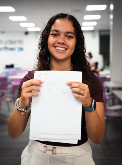 A female student holding her results